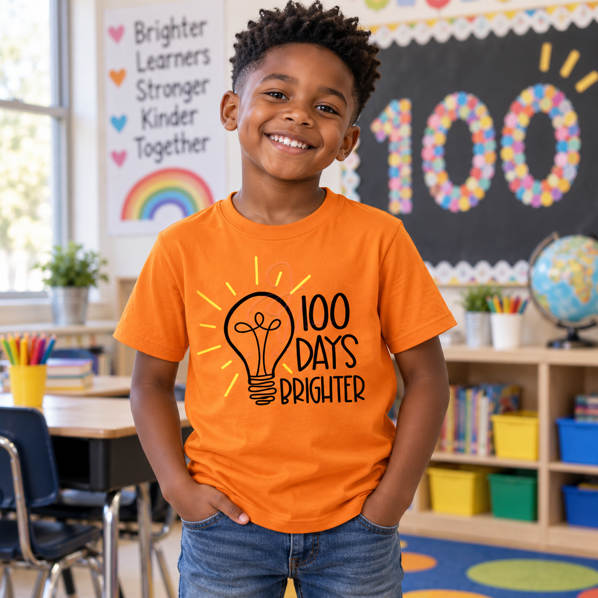 Black child wearing an orange 100 Days Brighter school tee in a classroom
