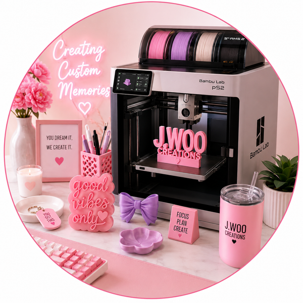 3D printer with pink-themed accessories and decor on a desk.