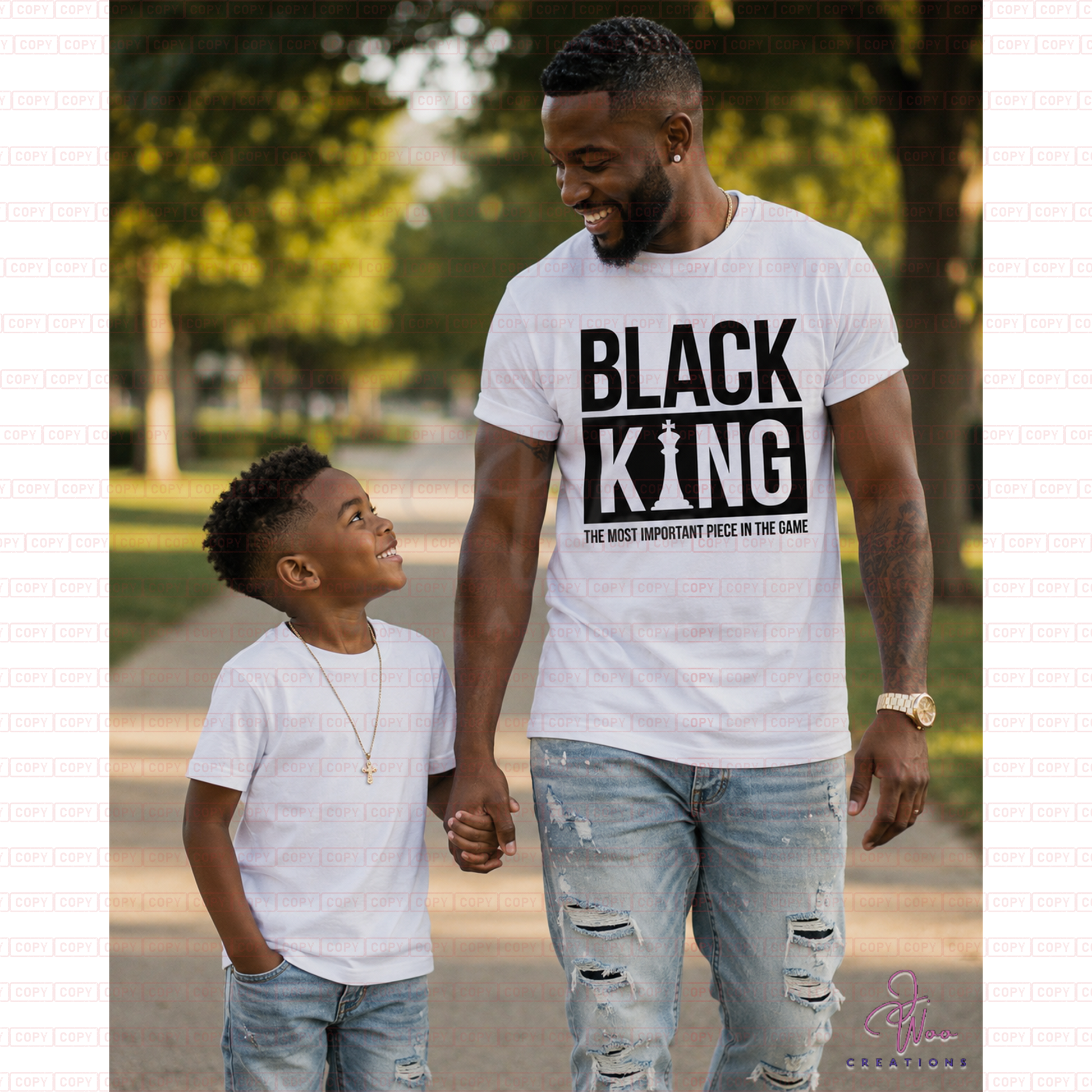 Man and child walking together in a park wearing 'BLACK KING' t-shirts.