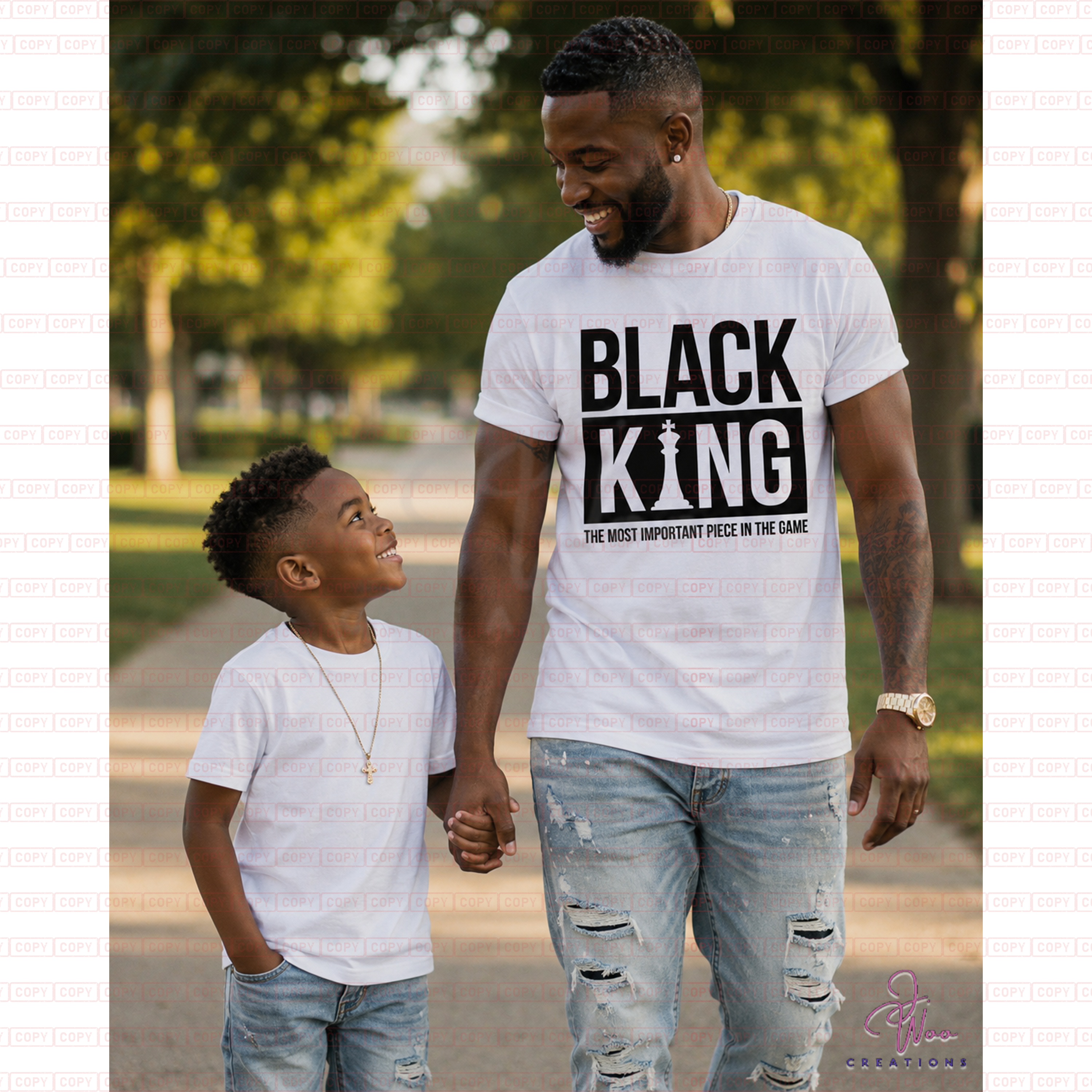 Man and child walking together in a park wearing 'BLACK KING' t-shirts.