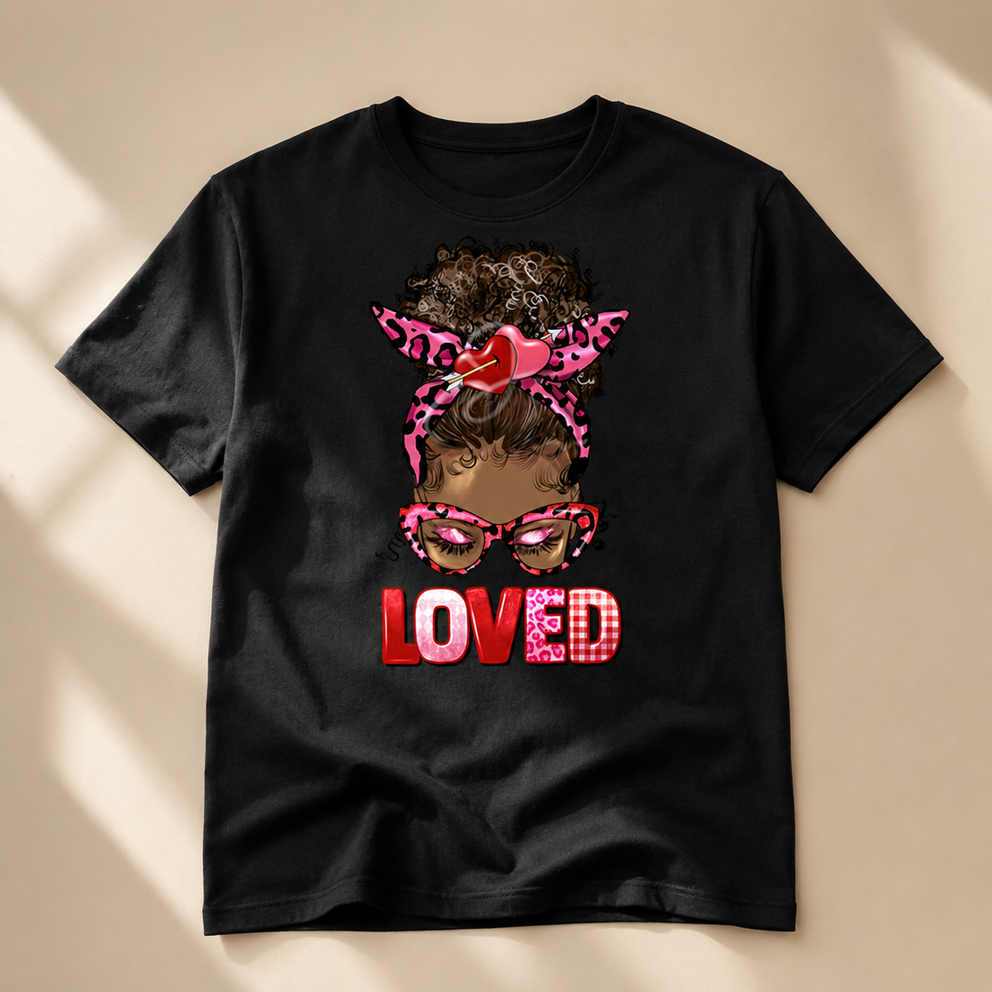 White Loved Afro Puff T-shirt with an illustrated Black girl, pink leopard-print bow, heart-shaped glasses, and red lettering